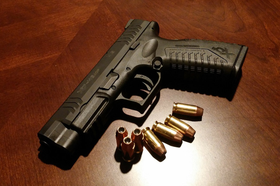 A handgun and ammo in the table